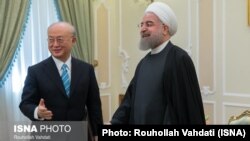 Iranian President Hassan Rohani (right) meets with UN nuclear chief Yukiya Amano in Tehran on December 18.