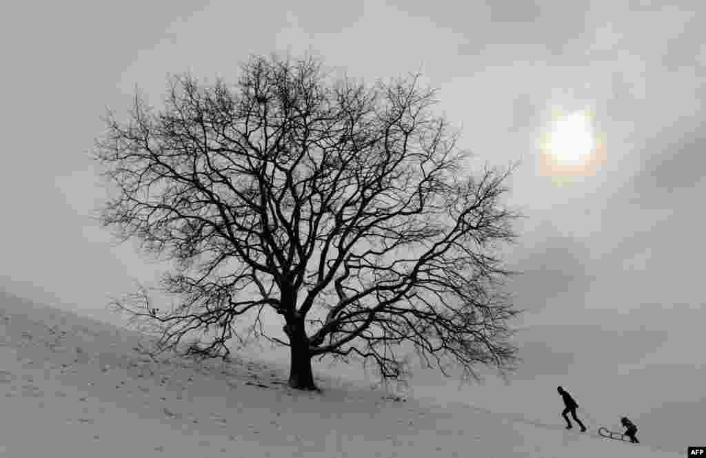 As cold weather grips Europe, bobsleigh riders walk on a small hill in the Olympic Park in Munich, Germany, on February 7 (AFP/Christof Stache)