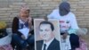 Сторонники Хосни Мубарака держат его портрет