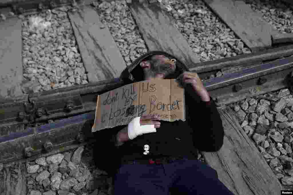 A Syrian refugee protests on railway tracks demanding the opening of the borders, at a makeshift camp &nbsp;near the Greek-Macedonian frontier. (Reuters/Alkis Konstantinidis)