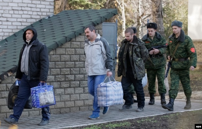 Ukrainian war prisoners are guarded by Luhansk separatists during a prisoner exchange in February 2016.
