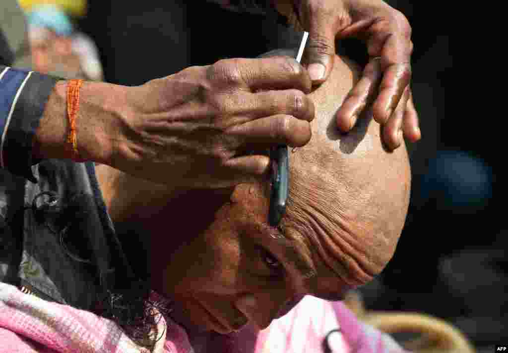 An Indian demonstrator gets his head shaved in protest following the death of a gang-rape victim in New Delhi. The brutal gang-rape of the 23-year-old medical student on December 16 has led to a bout of national soul-searching over the treatment of women in Indian society and provoked daily protests. (AFP/Prakash Singh)