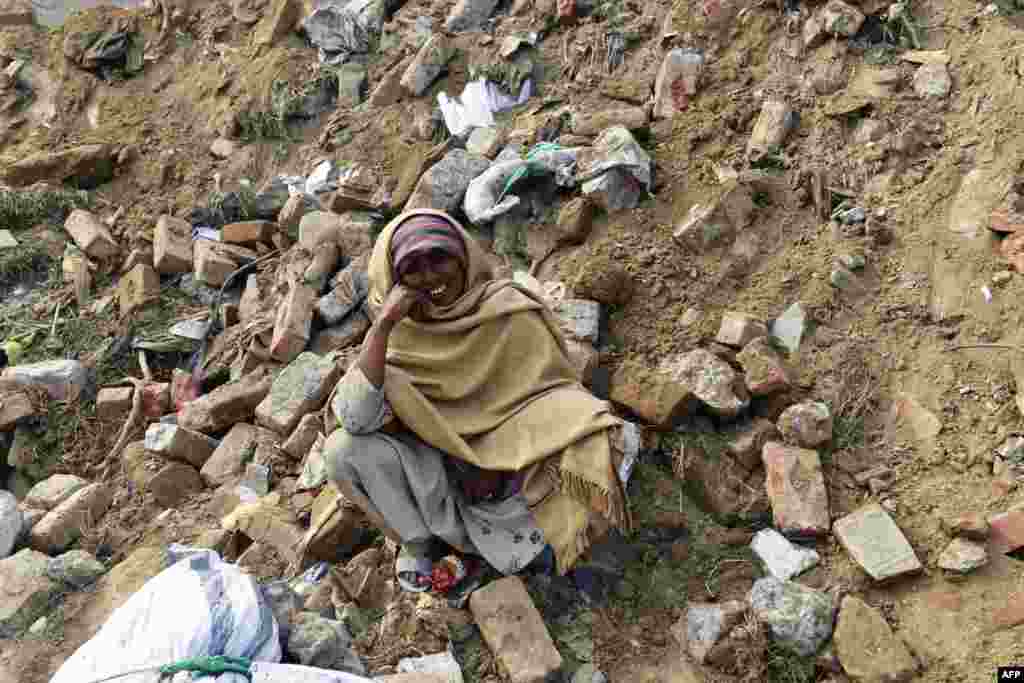 Nasreen Bibi waits for news of her son, who is missing under the rubble of a collapsed factory on the outskirts of Lahore, Pakistan. Pakistani rescuers pulled more than 100 people alive from the rubble and have retrieved the bodies of 22 who were killed. (AFP/Arif Ali)