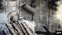 Syria -- A rebel fighter fires towards a Syrian government forces position in the northern Syrian city of Aleppo on 06Nov2012