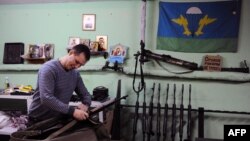 یکی از اعضای جنبش امپراطوری روسیه در حال آماده‌سازی تفنگ برای یک تریننگ