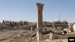 Afghan security officials inspect the site of a suicide bomb blast, in Paktia, September 29, 2014