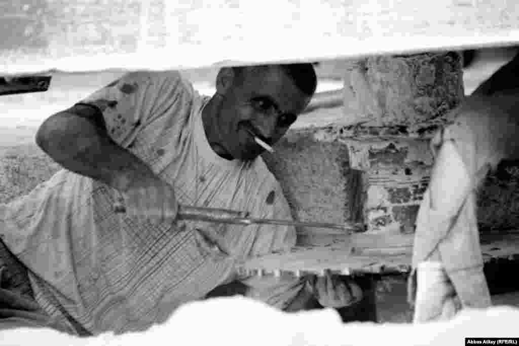 Zakir adjusts one of the stone-cutting machines, which require frequent servicing. 