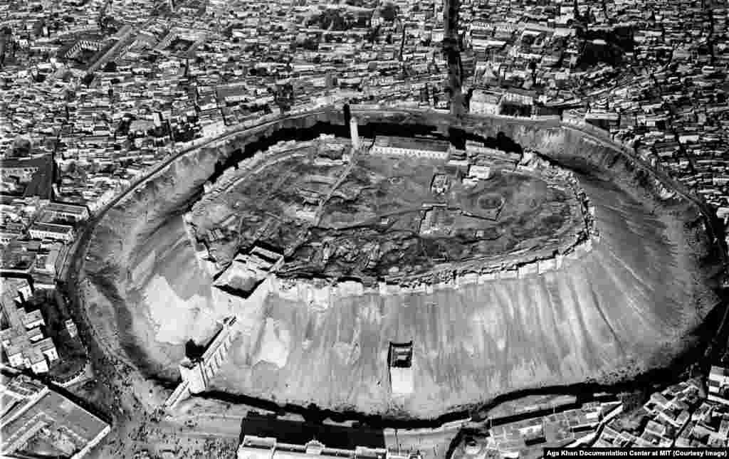 Pamje nga lart e Kalasë së Aleppo-së, e fotografuar në vitin 1937. Kur shkrimtarja Gertrude Bell vizitoi qytetin e famshëm tregtar në vitin 1907, &nbsp;ajo e krahasoi atë &quot;një filxhan dhe një pjatë, shtëpitë qëndrojnë në pjatë dhe kalaja si një filxhan i kthyer përmbys&quot;.