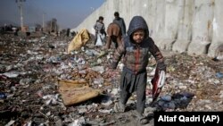 An Afghan child looks for plastic and other items, which can be used as a replacement for firewood, at a garbage dump in Kabul. (file photo)