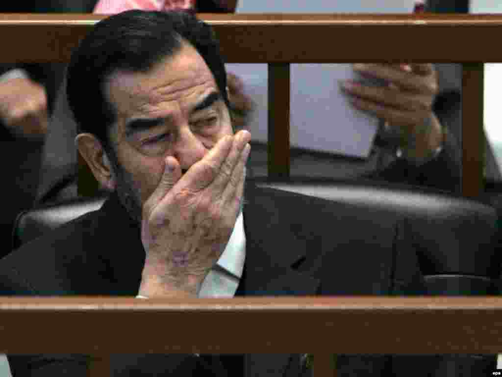 Iraq -- Saddam Hussein yawns while listening to the prosecution during the 'Anfal' genocide trial in Baghdad, 20Dec2006 - Äl-Dücäil eşe tikşerelgän arada Säddamğa ikençe ğäyepläw belderde. Ul 1987-1988 yıllarda Kördlärgä qarşı oyıştırılğan kampaniä barışında 180 meñläp keşeneñ üterelüe öçen ğäyeplände. 2006neñ 20 Dikäberendä töşerelgän bu räsemdä, Säddam mäxkämä utırışında isnäp töşkän. (epa)