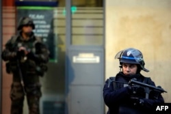 Полицейский и солдат вместе патрулируют предместье Парижа Сен -Дени, 18 ноября 2015 года