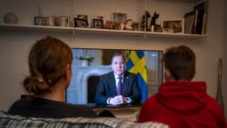 Ljudi u svojim domovima gledaju obraćanje premijera Stefana Lofvena, Štokholm