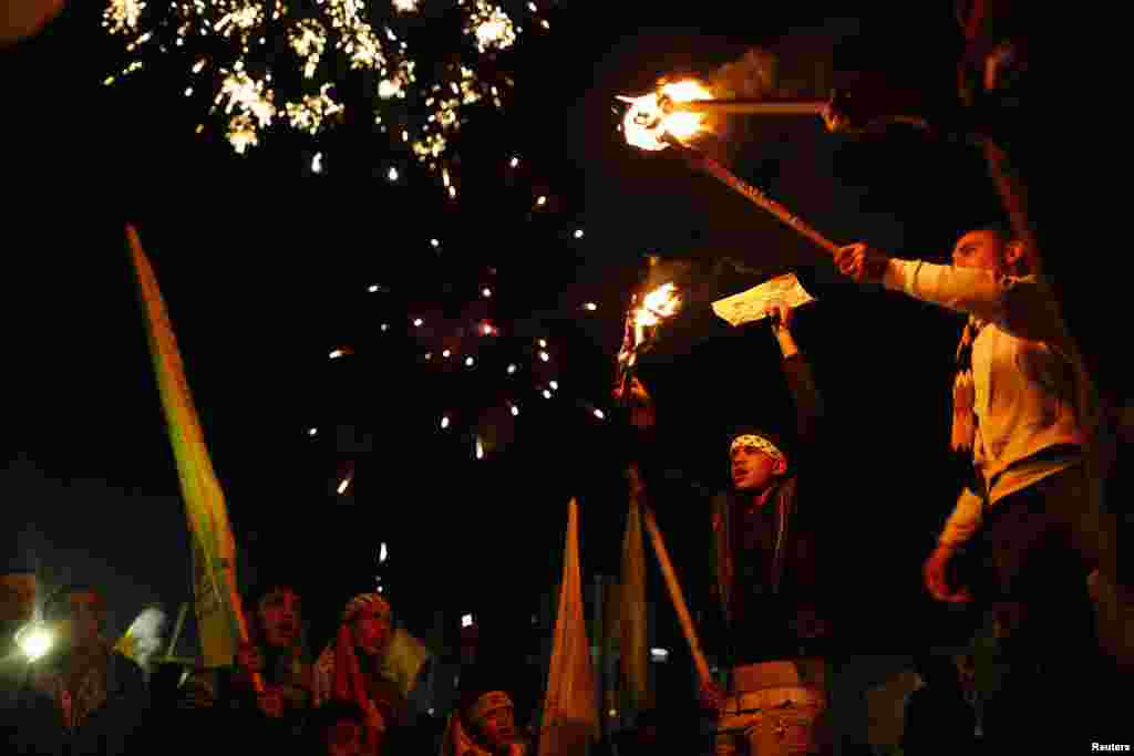 Palestinians hold torches as they celebrate the 48th anniversary of the founding of the Fatah movement in Gaza City. (Reuters/Mohammed Salem)