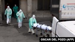 Испания дәрігерлерді коронавирустан қайтыс болған адамның денесін шығарып жатыр. 2020 жылдың наурызы.