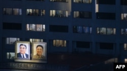 Portraits of late North Korean leaders Kim Il Sung (left) and Kim Jong Il are displayed on the side of a building in Pyongyang.