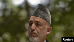 Afghan President Hamid Karzai at a July 12 news conference with his French counterpart, Nicolas Sarkozy, after Karzai's brother was shot dead earlier the same day in Kandahar