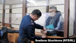 С пастора пресвитерианской церкви «Благодать» Бахтжана Кашкумбаева снимают наручники в зале судебного заседания. Астана, 22 января 2014 года. 