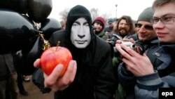 A protester wearing a mask of Russian President Vladimir Putin participates in a rally in protest against Russian actions in Crimea in St. Petersburg in March 2014.