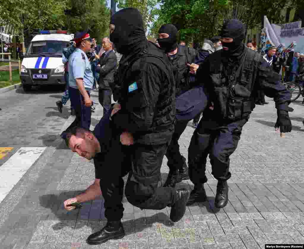 Полицейский спецназ задерживает участников несанкционированной акции протеста с требованием &quot;освободить политических заключенных&quot;. Алматы, 10 мая 2018 года.