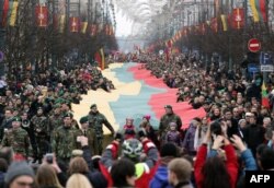 Lithuanians march with a national flag during a parade to mark the 25th anniversary of independence from the Soviet Union in Vilnius.