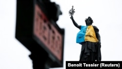 Статуя Маріанни, одягнена в український прапор, на знак протесту проти російського вторгнення в Україну в Парижі, Франція, 13 березня 2022 року