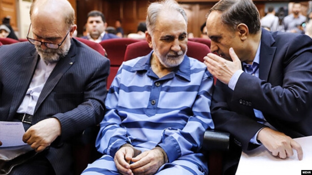 Mohammad Ali Najafi (center) in handcuffs in a Tehran court