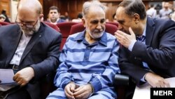 Mohammad Ali Najafi (center) in handcuffs in a Tehran court