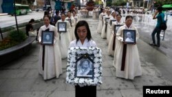 Участники поминальной церемонии несут портреты женщин, превращенных в сексуальных рабынь в японских борделях во время Второй мировой войны, Сеул, 2013 год.