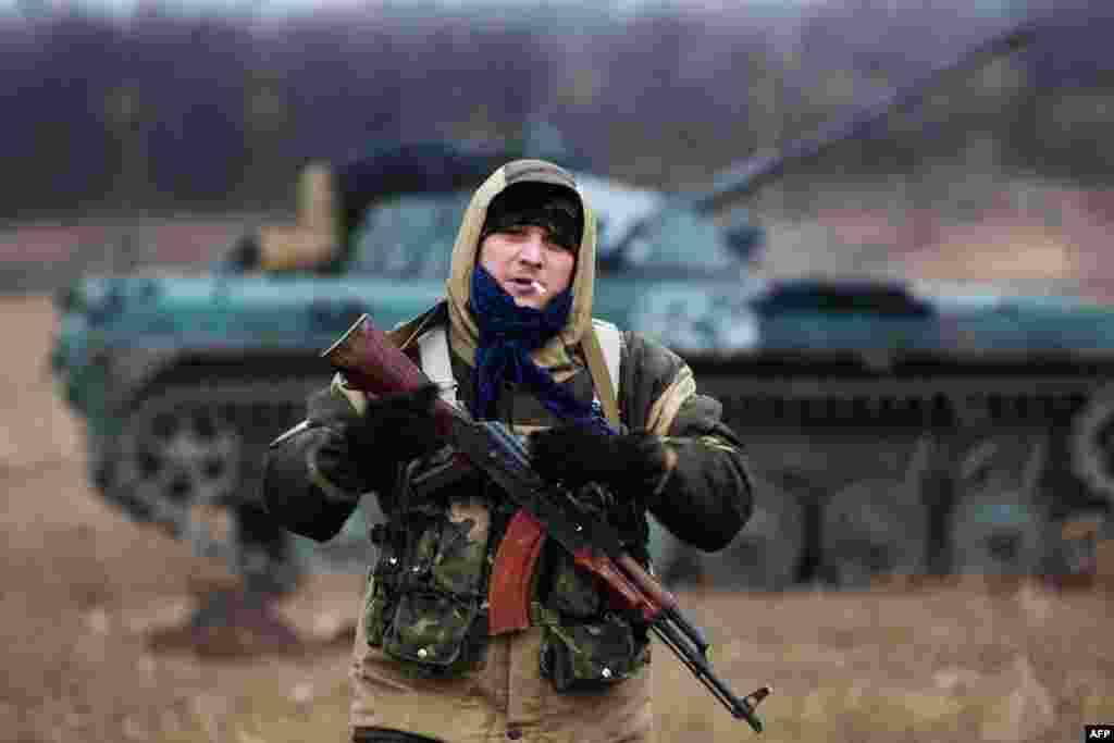 A pro-Russian militant poses in front of a tank captured from Ukrainian forces in the eastern town of Ilovaysk, some 40 kilometers east of Donetsk. (AFP/Menahem Kahana)