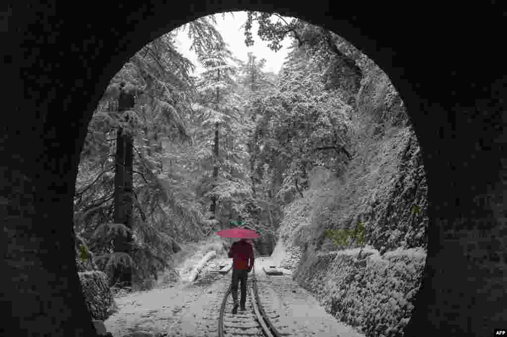 A man walks along a snow-covered railway track in Shimla in northern India on February 8. Parts of Asia have also been hit by unusually cold weather. (AFP)