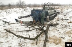 Pro-Russia rebels stand next to an armored military vehicle on the front line near the eastern Ukrainian town of Svitlodarsk on December 19.