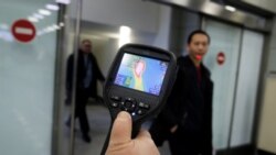 Сотрудник СЭС проверяет температуру тела пассажиров в аэропорту. Алматы, 21 января 2020 года.