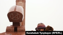 Алтынбек Сәрсенбайұлының жұбайы Салтанат Атушева ерінің бейіті басында отыр. Алматы, 11 ақпан 2012 жыл.