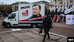 A woman passes a small truck with a preelection billboard with a portrait of Oleh Lyashko, the leader of Ukraine's populist Radical Party, in the eastern town of Kramatorsk, near Slovyansk, on October 23.