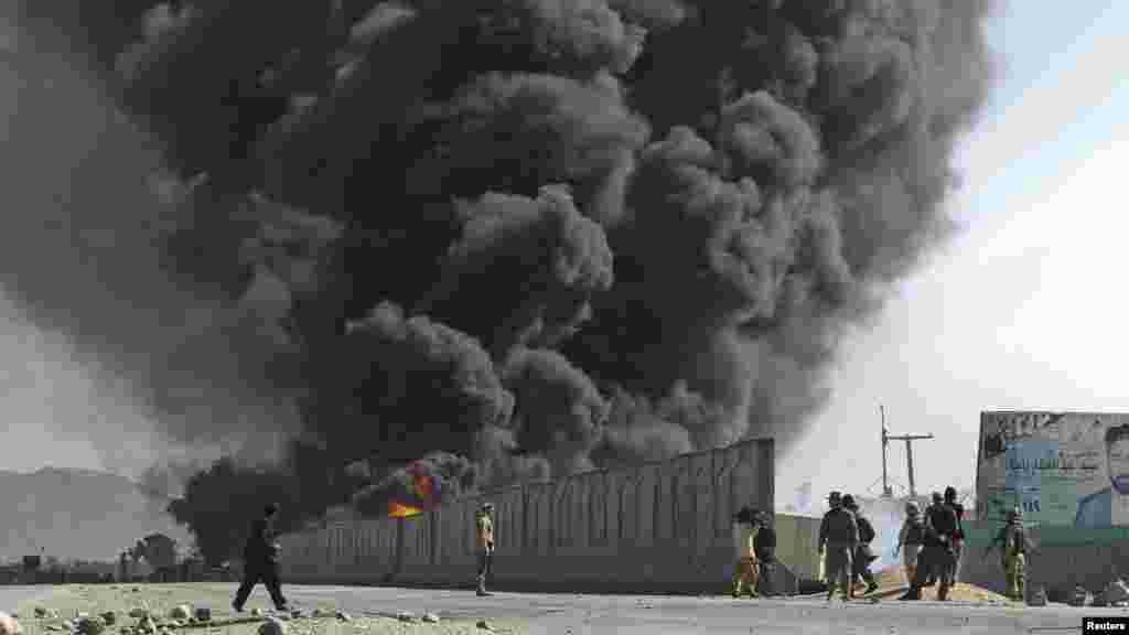 Smoke billows from a fuel tank supplying NATO troops after it was set on fire by protesters during a demonstration in Jalalabad on February 22.