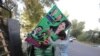 Supporters of opposition political party Pakistan Muslim League Nawaz (PMLN) install posters at the party's senior leaders residence in Lahore as major political parties gear up for an anti-government rally on October 15 