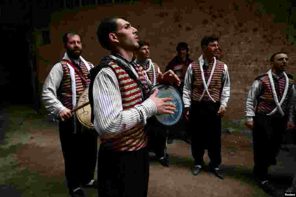 Men, wearing traditional costumes, play music during a wedding ceremony in the besieged rebel-held town of Kafr Batna on the outskirts of Damascus, Syria. (Reuters/Bassam Khabieh)