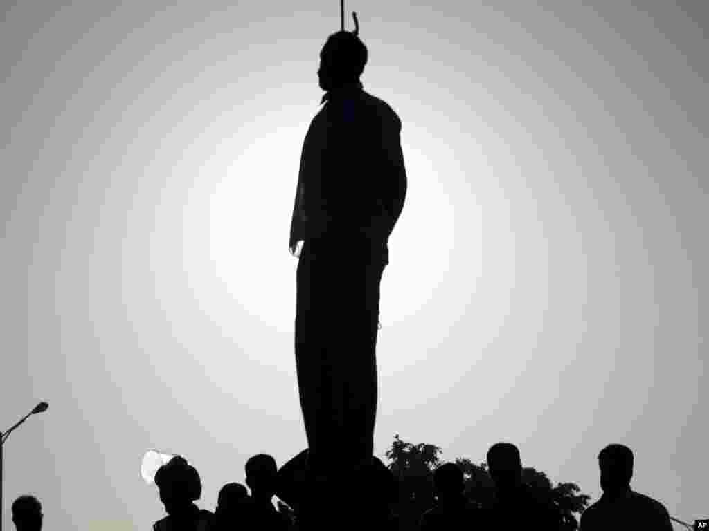 Silhouette of a convicted man, Mahdi Faraji, is seen while he is being hanged in the city of Qazvin, 130 kilometers west of the Iranian capital, Tehran, on May 26. Iran's official news agency reported that five prisoners were hanged in public, including a convicted serial killer. The others had been found guilty of rape and armed robbery. This brought the number of executions to 130 since the beginning of the year. Photo by Hamideh Shafieeha for AP/Mehr