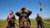 An Iraqi Kurdish female fighter looks through binoculars during a deployment near the front line of the fight against Islamic State militants in Nawaran, near Mosul, in April.