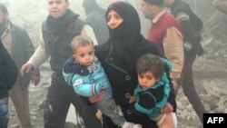 Әуе шабуылы кезінде балаларын көтеріп алған сириялық әйел, Алеппо провинциясы. (Көрнекі сурет)