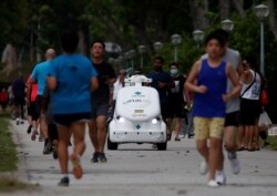 Робот, который весной 2020 года ездил по улицам Сингапура и напоминал бегунам о необходимости соблюдать социальную дистанцию