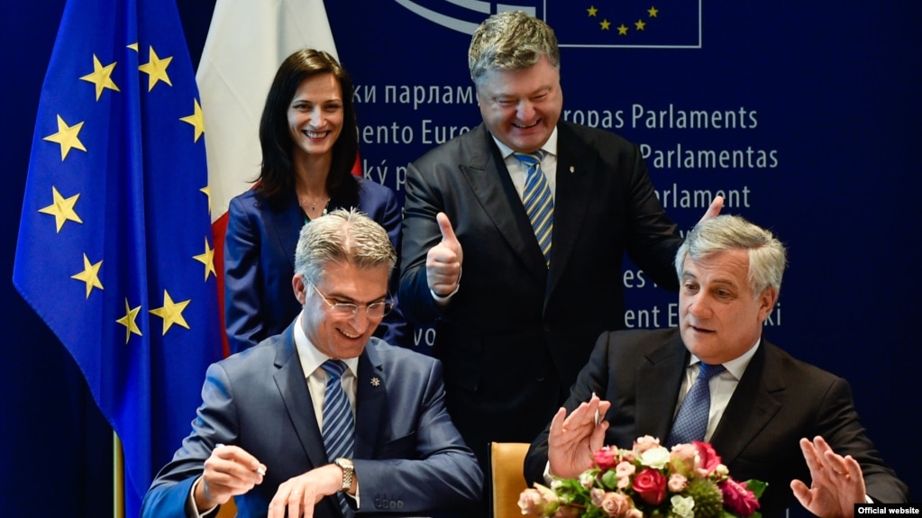 Ukrainian President Petro Poroshenko (top right) looks on as he attends the signing ceremony for a new visa-liberalization regime with the European Union in Strasbourg on May 17.
