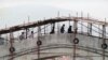 BOSNIA-HERZEGOVINA -- Residents pass over a more than 500-year-old bridge over the Neretva River, which is protected with wooden scaffolding, in the old part of the Bosnian city of Mostar, April 12, 1993