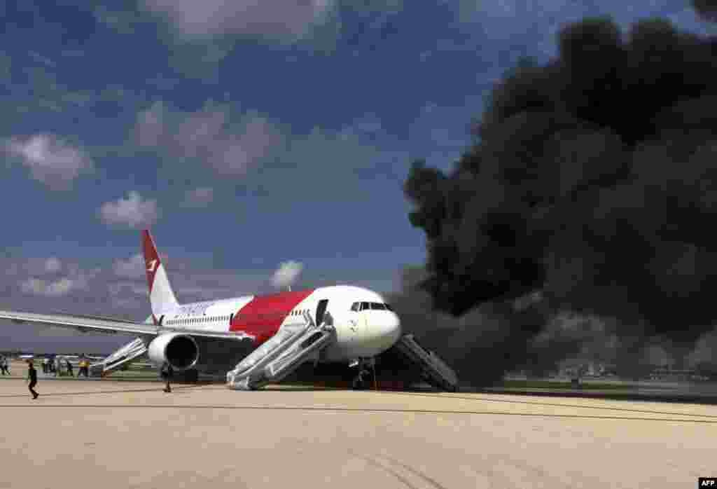 Passengers evacuate a plane that was on fire at the airport in Fort Lauderdale, Florida. Several people were injured when the jet plane's engine caught fire as it prepared for takeoff. (AFP/Andres Gallego)