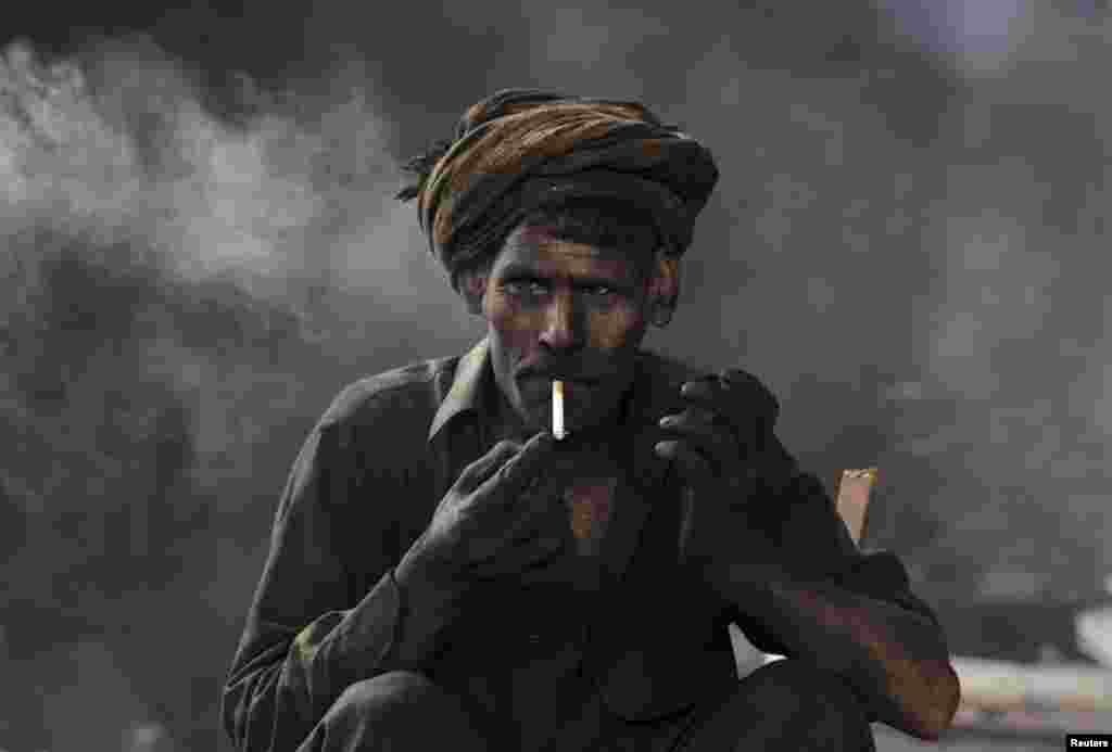 A worker takes a break from his work at a steel-smelting plant in Lahore, Pakistan. (Reuters/Mohsin Raza)