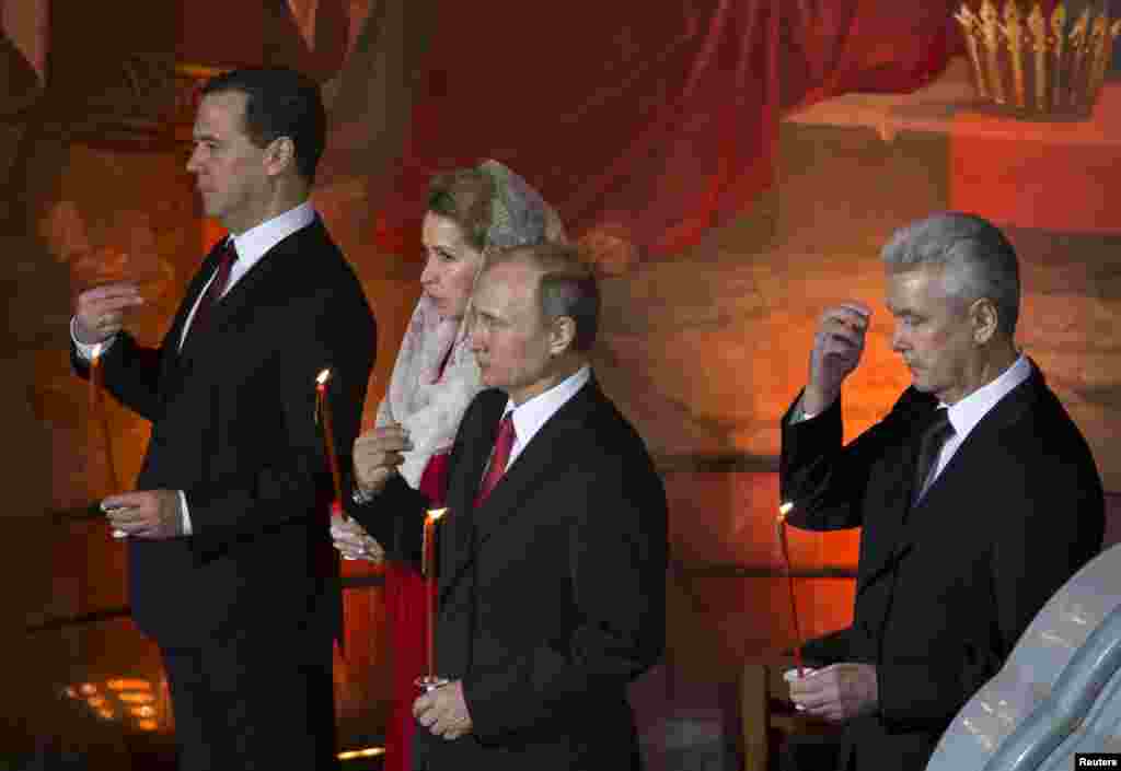 Președintele Vladimir Putin, primarul Moscovei, Serghei Sobianin, premierul Dmitri Medvedev și soția sa Svetlana, rugîndu-se în timpul slujbei de Paște la Catedrala Mîntuitorului de la Moscova la 12 aprilie. &nbsp;