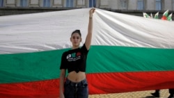 A protester holds a giant Bulgarian flag during September 2020 protests in front of the parliament building in Sofia.
