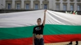 Девојка држи огромно бугарско знаме за време на протестот во септември 2020 година пред зградата на парламентот во Софија