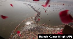 Një helikopter hedh petale trëndafili mbi besimtarët që kryejnë rituale gjatë Festivalit Kumbh Mela në Indi.