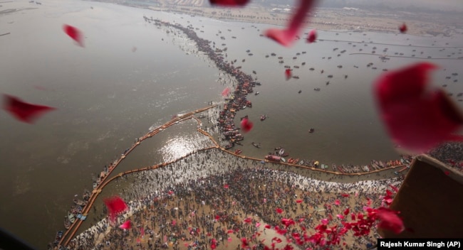 Një helikopter hedh petale trëndafili mbi besimtarët që kryejnë rituale gjatë Festivalit Kumbh Mela në Indi.